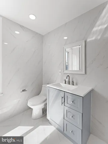 a bathroom with a toilet a sink a mirror and vanity