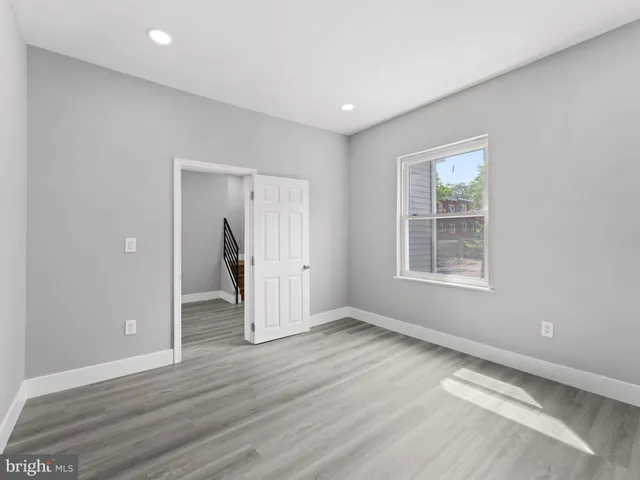 an empty room with wooden floor and a window