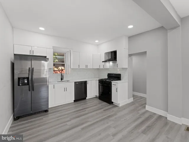 a kitchen with a refrigerator a sink and cabinets