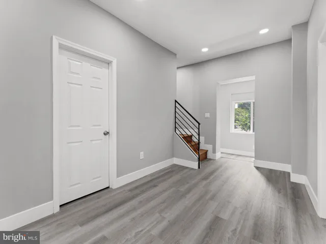an empty room with wooden floor and a window