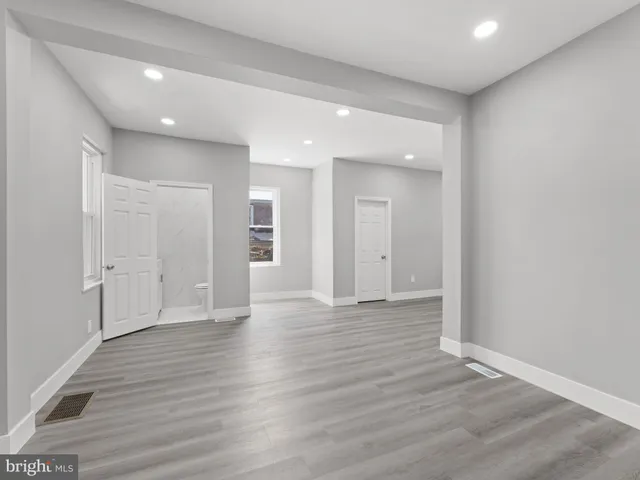 a view of an empty room with wooden floor and closet