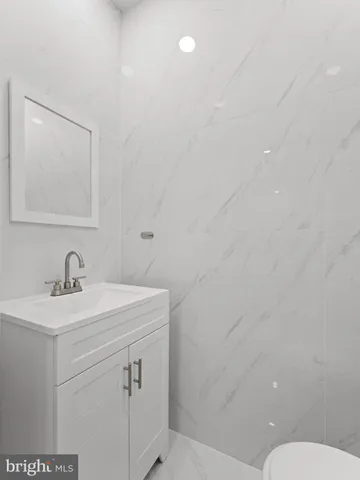 a bathroom with a sink vanity mirror and toilet