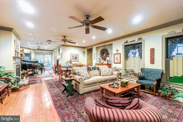 a living room with furniture kitchen view and a large window