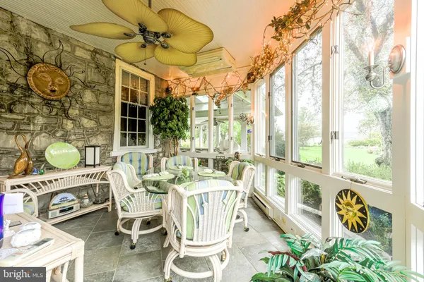 a dining room with furniture a chandelier and a floor to ceiling window