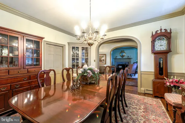 a dining room with furniture a chandelier and wooden floor