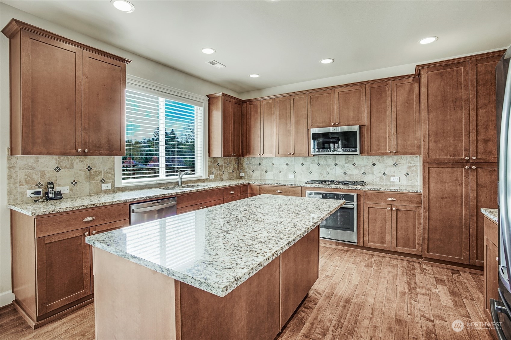 6127 Southeast 2nd Street Renton, WA 98059 - Photo 5 of 33 a kitchen with kitchen island granite countertop wooden cabinets a sink and a stove