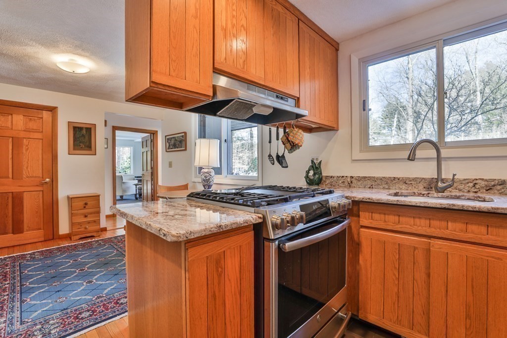 121 West Bare Hill Road Harvard, MA 01451 - Photo 12 of 36 a kitchen with stainless steel appliances granite countertop wooden cabinets and a stove top oven