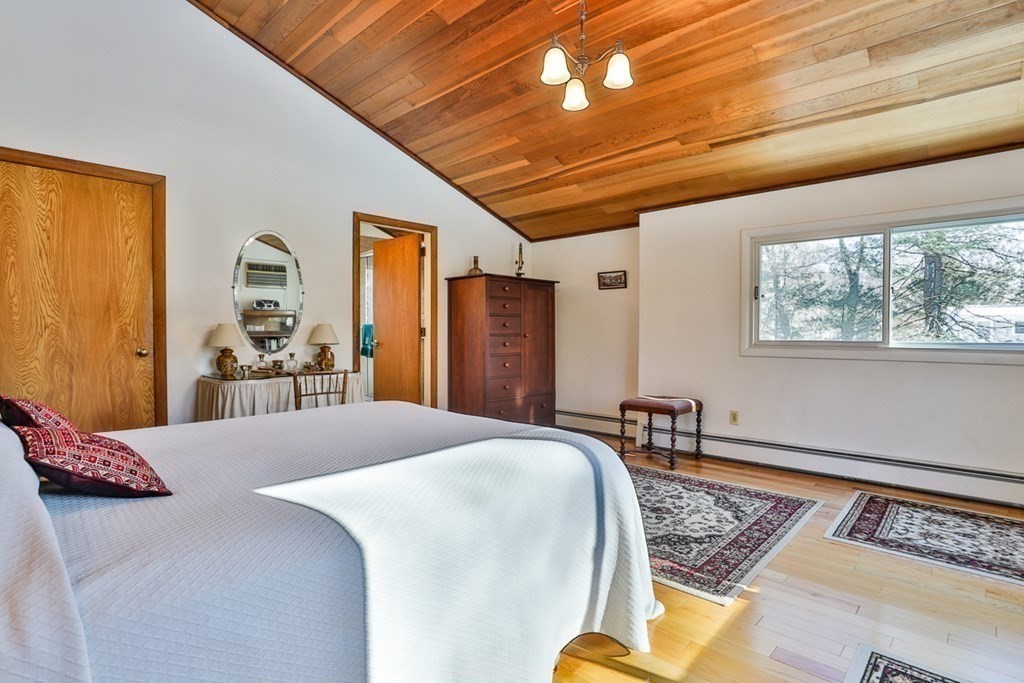 121 West Bare Hill Road Harvard, MA 01451 - Photo 29 of 36 a bedroom with a bed next to a window and a chandelier