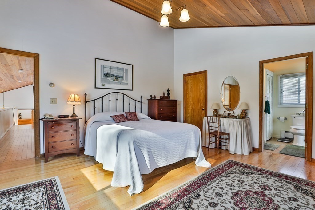 121 West Bare Hill Road Harvard, MA 01451 - Photo 30 of 36 a bedroom with a bed and a chandelier