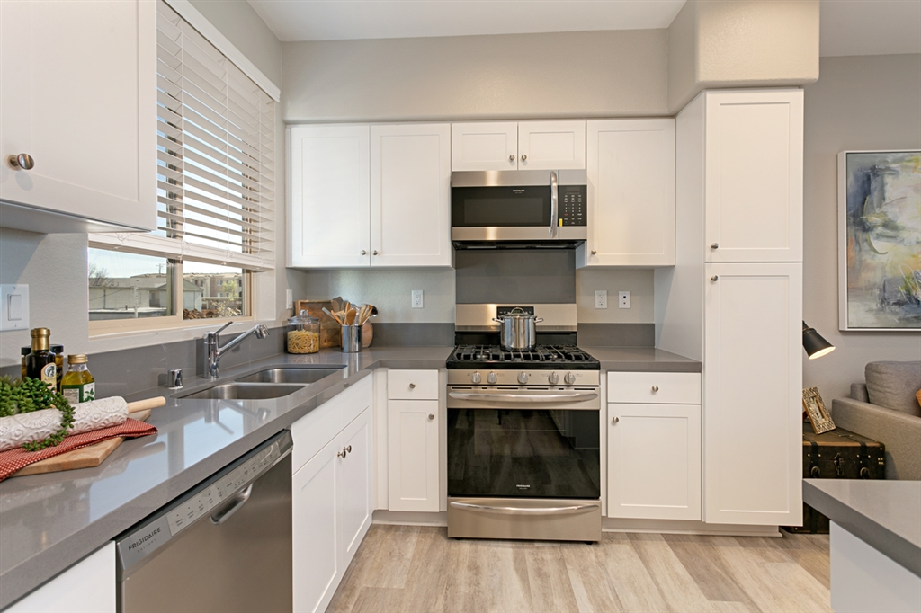 8850 Olive Lane, Unit 9 Santee, CA 92071 - Photo 2 of 17 The open kitchen features quartz countertops and stainless steel appliances. This is a picture of the new furnished model.