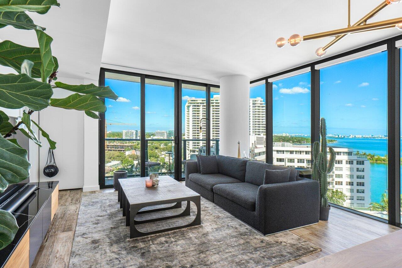 650 Northeast 32nd Street, Unit 1508 Miami, FL 33137 - Photo 6 of 37 a living room with furniture large windows a rug and a chandelier