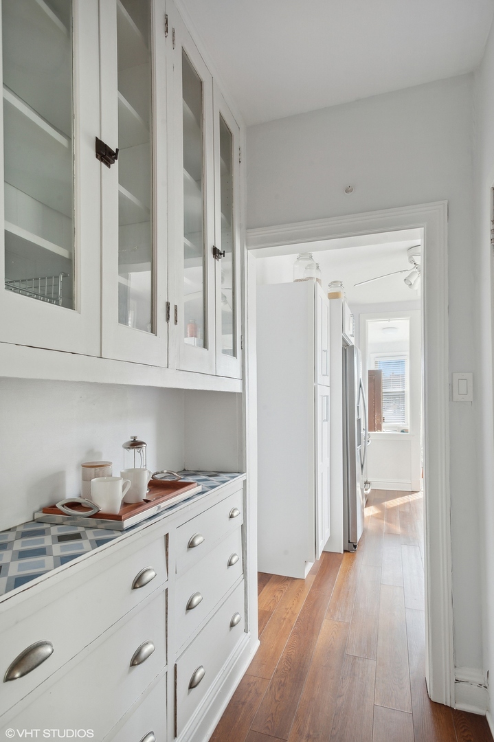 559 West Roscoe Street, Unit 2W Chicago, IL 60657 - Photo 15 of 23 a hallway with cabinets and wooden floor