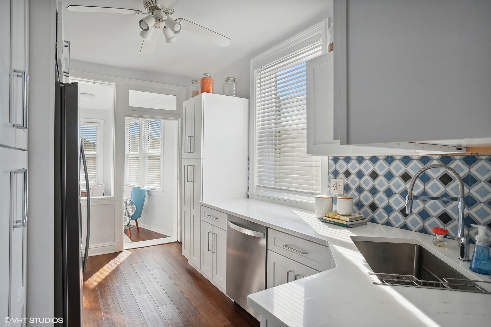559 West Roscoe Street, Unit 2W Chicago, IL 60657 - Photo 17 of 23 a view of a kitchen with a sink and dishwasher with wooden floor