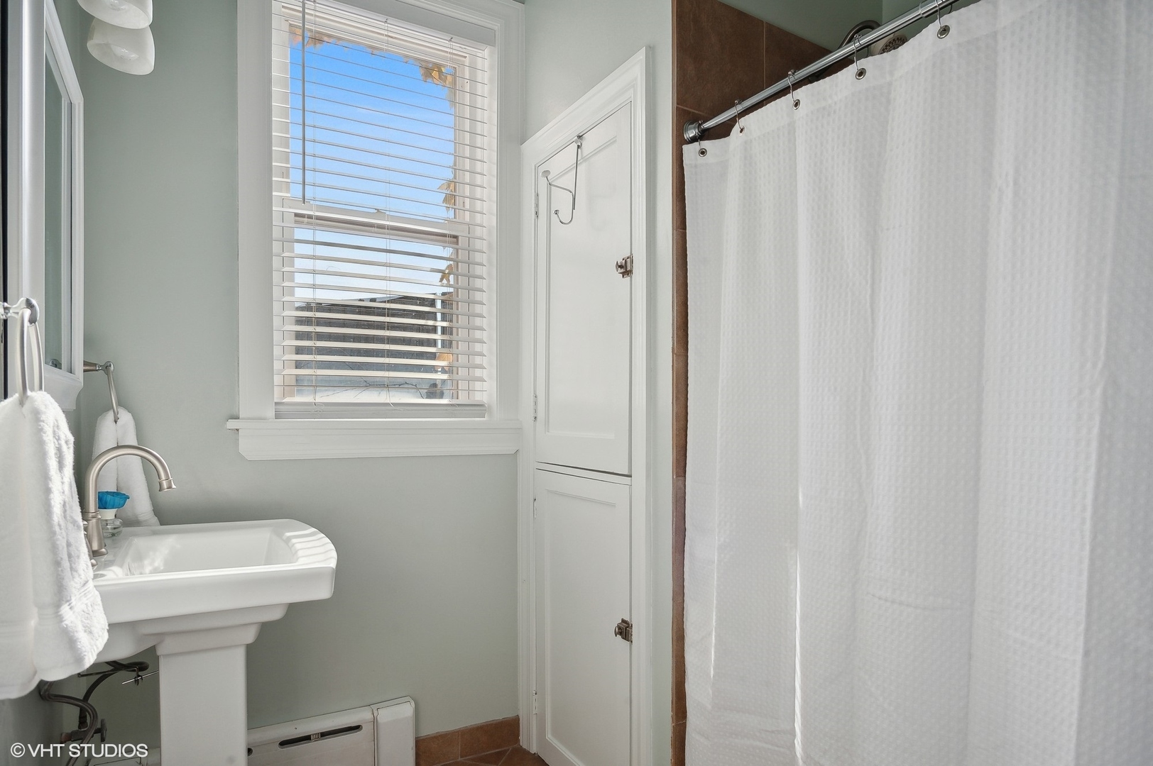 559 West Roscoe Street, Unit 2W Chicago, IL 60657 - Photo 9 of 23 a bathroom with a sink a toilet and a mirror