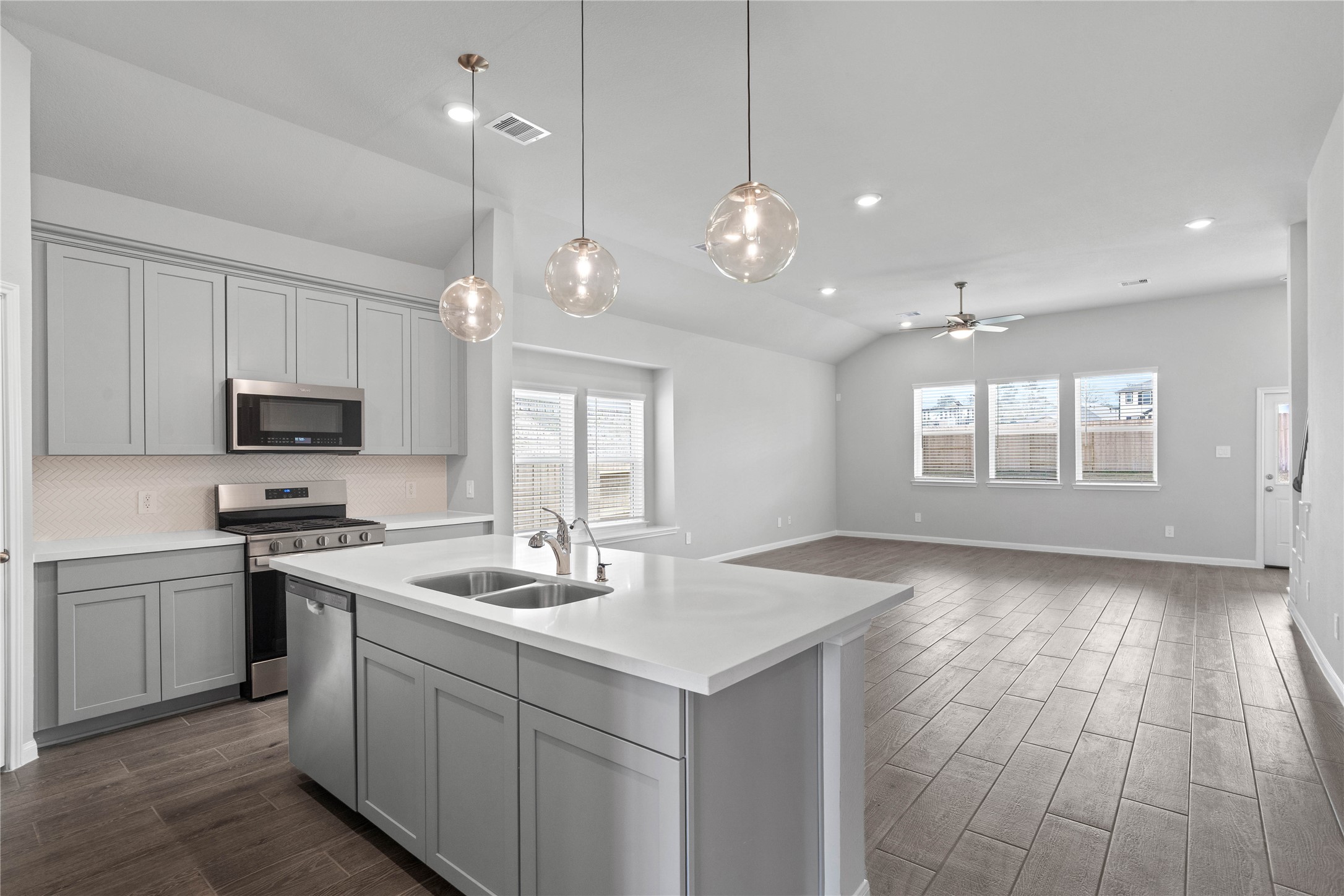 19657 Montgomery Rdg Way Montgomery, TX 77316 - Photo 19 of 49 From the expansive kitchen island, enjoy seamless sightlines across the open-concept dining and living areas, making entertaining a breeze and ensuring you're never far from the conversation.
