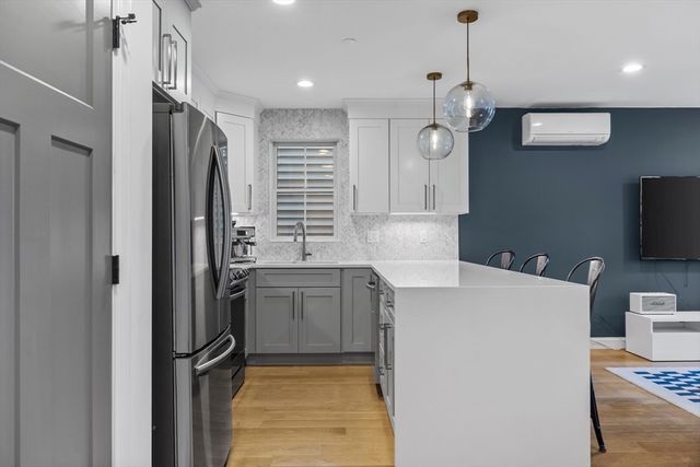 a kitchen with kitchen island a counter top space a sink stainless steel appliances and cabinets