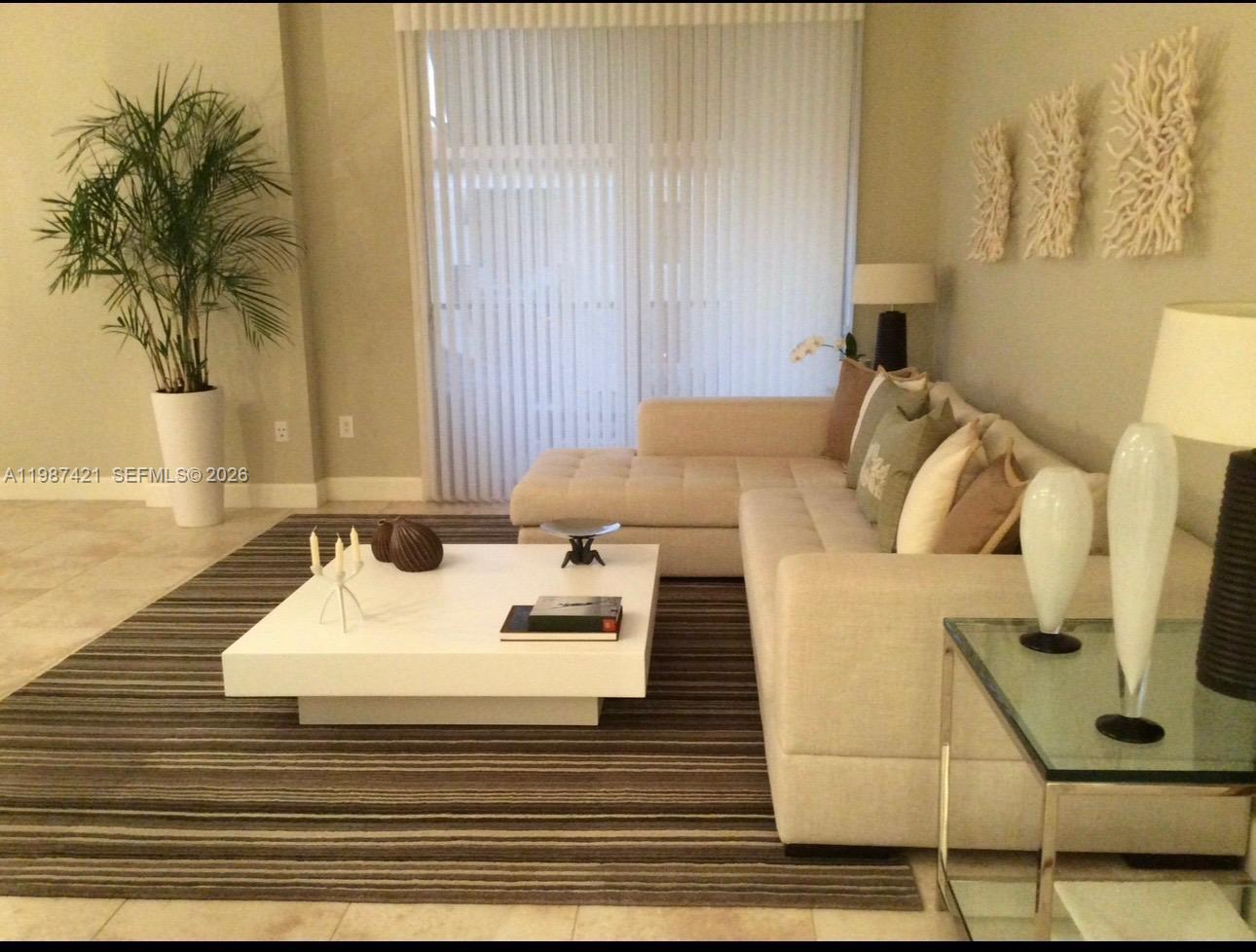 55 Merrick Way, Unit 825 Coral Gables, FL 33134 - Photo 2 of 26 a bed room with a bed a couch and a potted plant