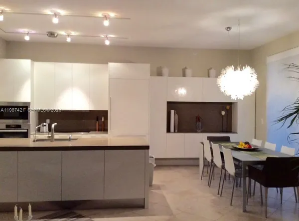 a kitchen with a sink dining table and chairs