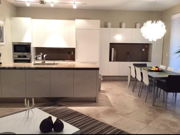a living room with stainless steel appliances kitchen island granite countertop furniture and a flat screen tv