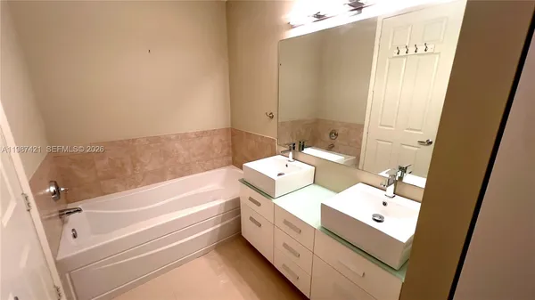 a bathroom with a tub sink and mirror