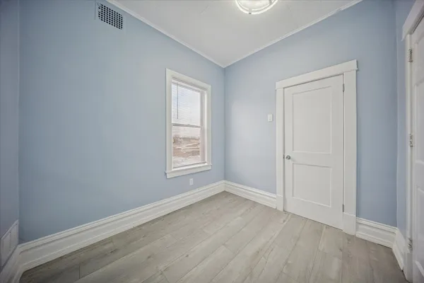 an empty room with wooden floor and window
