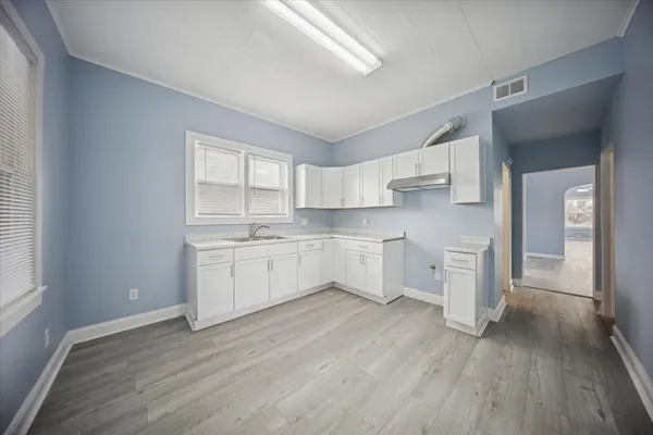 a kitchen with white cabinets and white appliances
