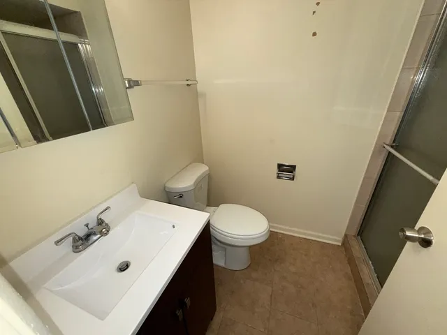 a bathroom with a sink a toilet and shower