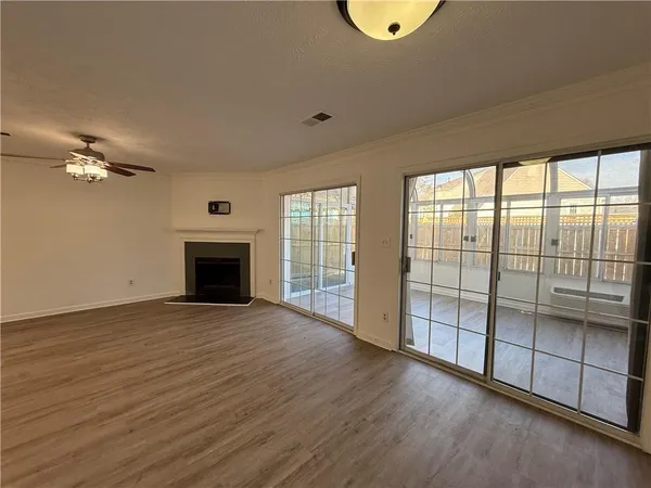 a view of an empty room with window and wooden floor