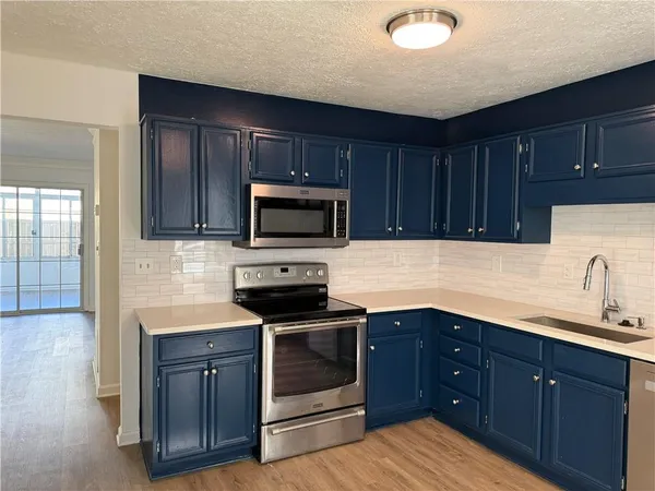 a kitchen with sink a microwave and cabinets