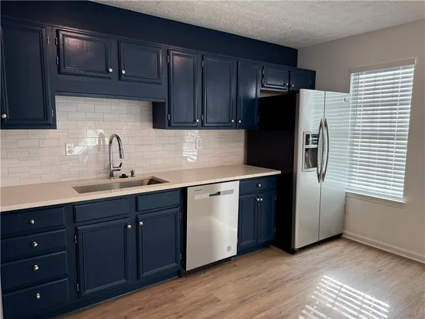 a kitchen with stainless steel appliances granite countertop a refrigerator and a sink