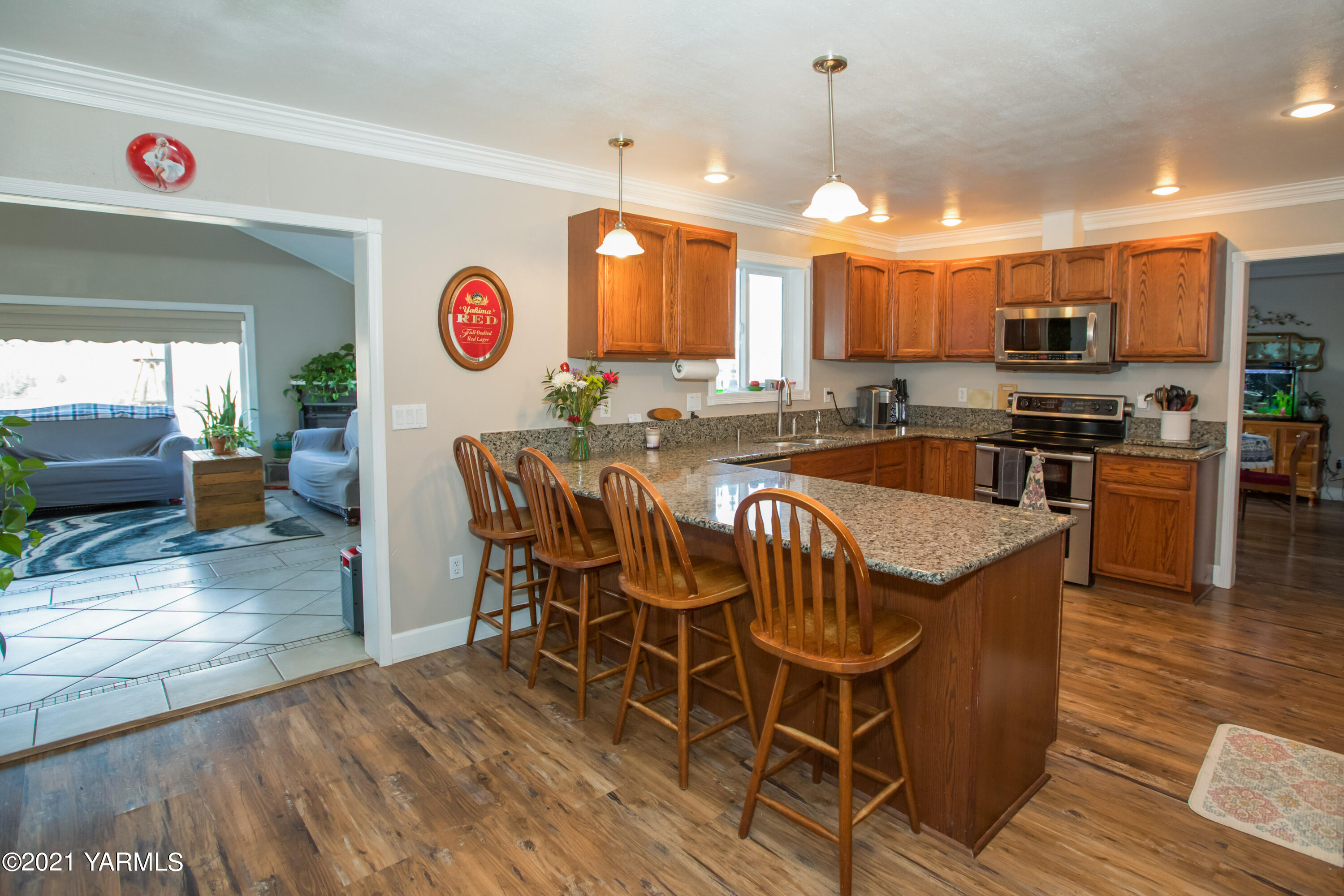 11401 Flintstone Road Yakima, WA 98908 - Photo 5 of 16 a kitchen with stainless steel appliances granite countertop a stove top oven a sink a dining table and chairs with wooden floor