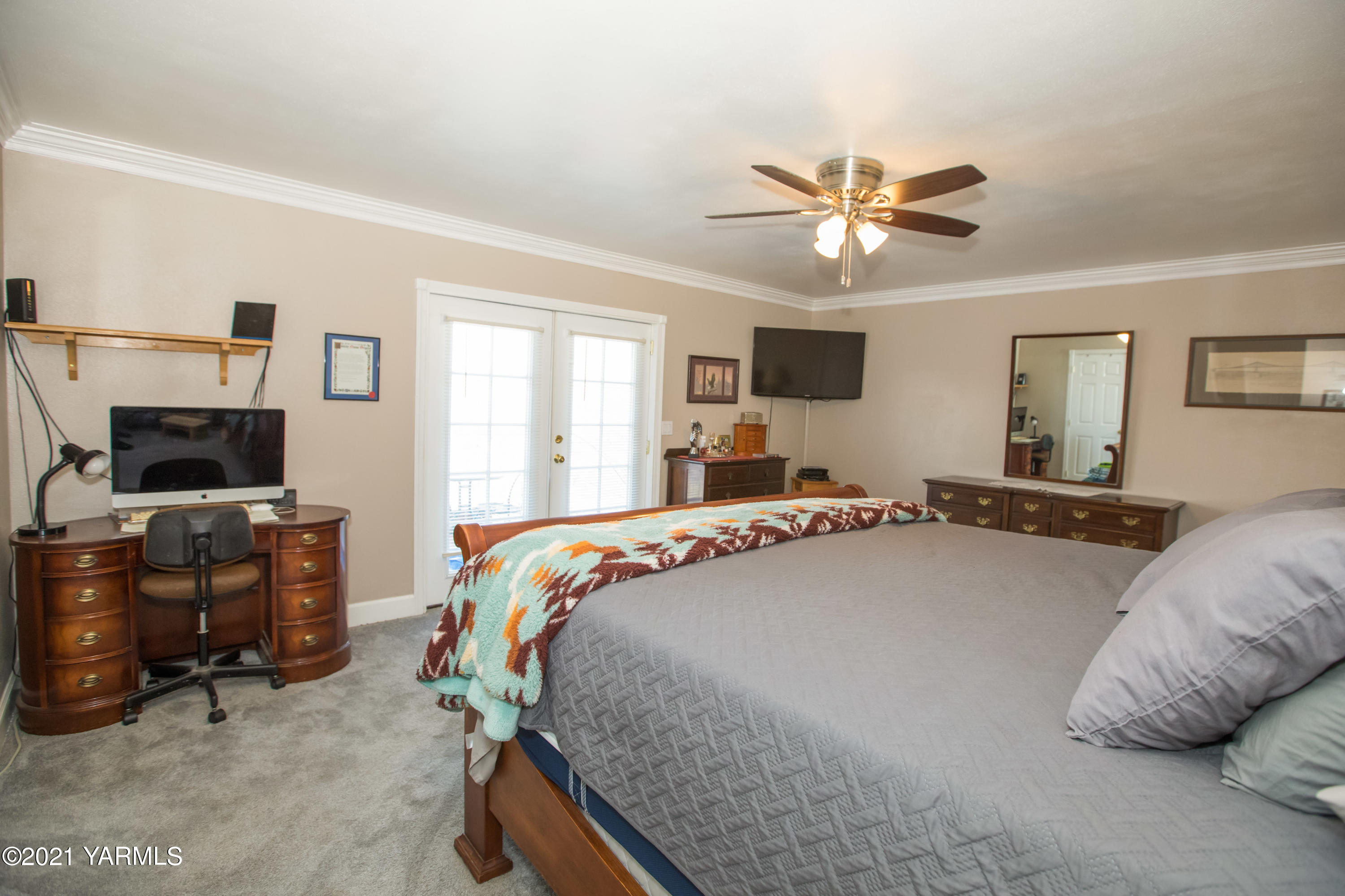 11401 Flintstone Road Yakima, WA 98908 - Photo 9 of 16 a bedroom with a bed a dresser and a chandelier
