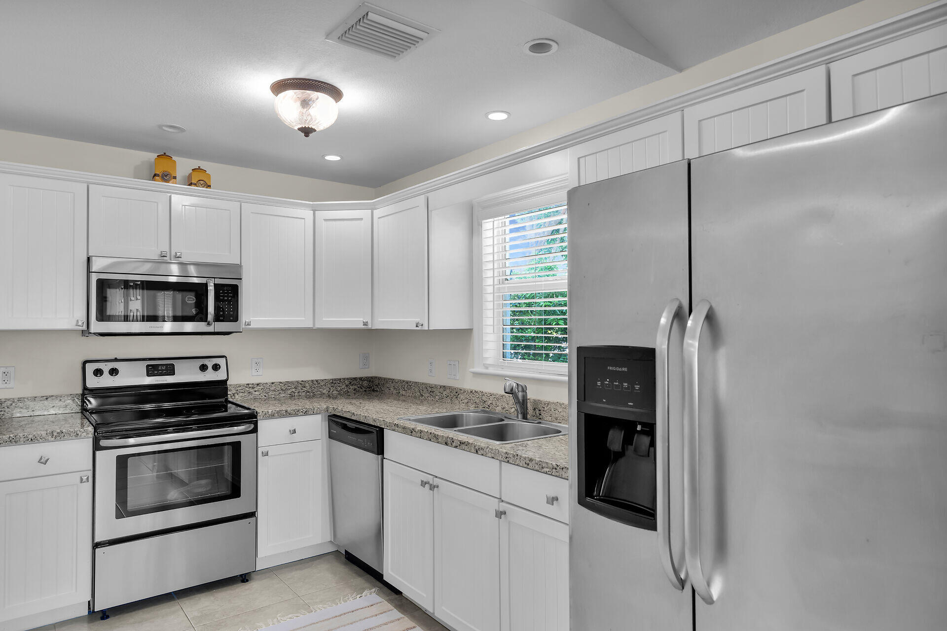 894 La Paloma Road Key Largo, FL 33037 - Photo 11 of 37 a kitchen with stainless steel appliances white cabinets and a sink