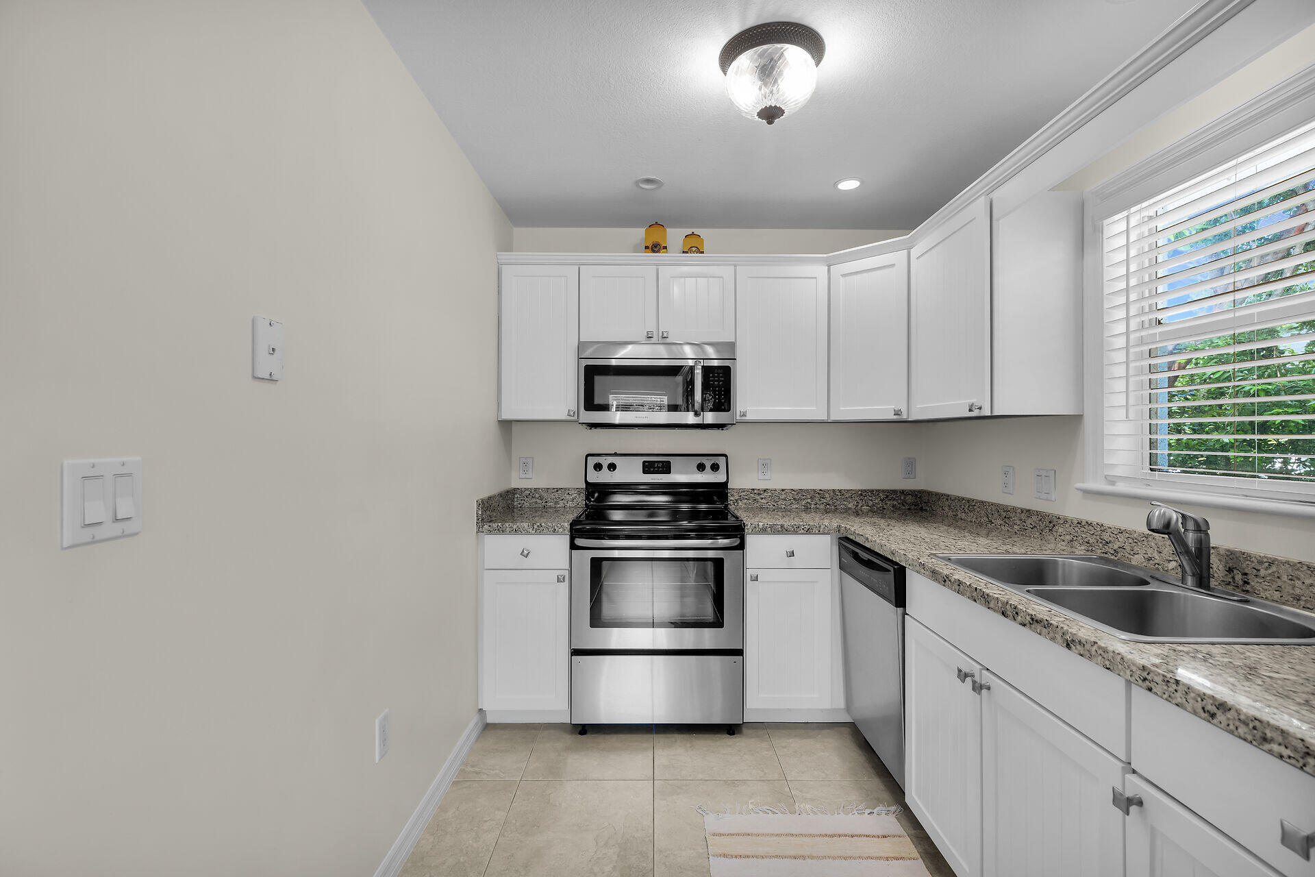 894 La Paloma Road Key Largo, FL 33037 - Photo 12 of 37 a kitchen with stainless steel appliances granite countertop a sink stove and refrigerator