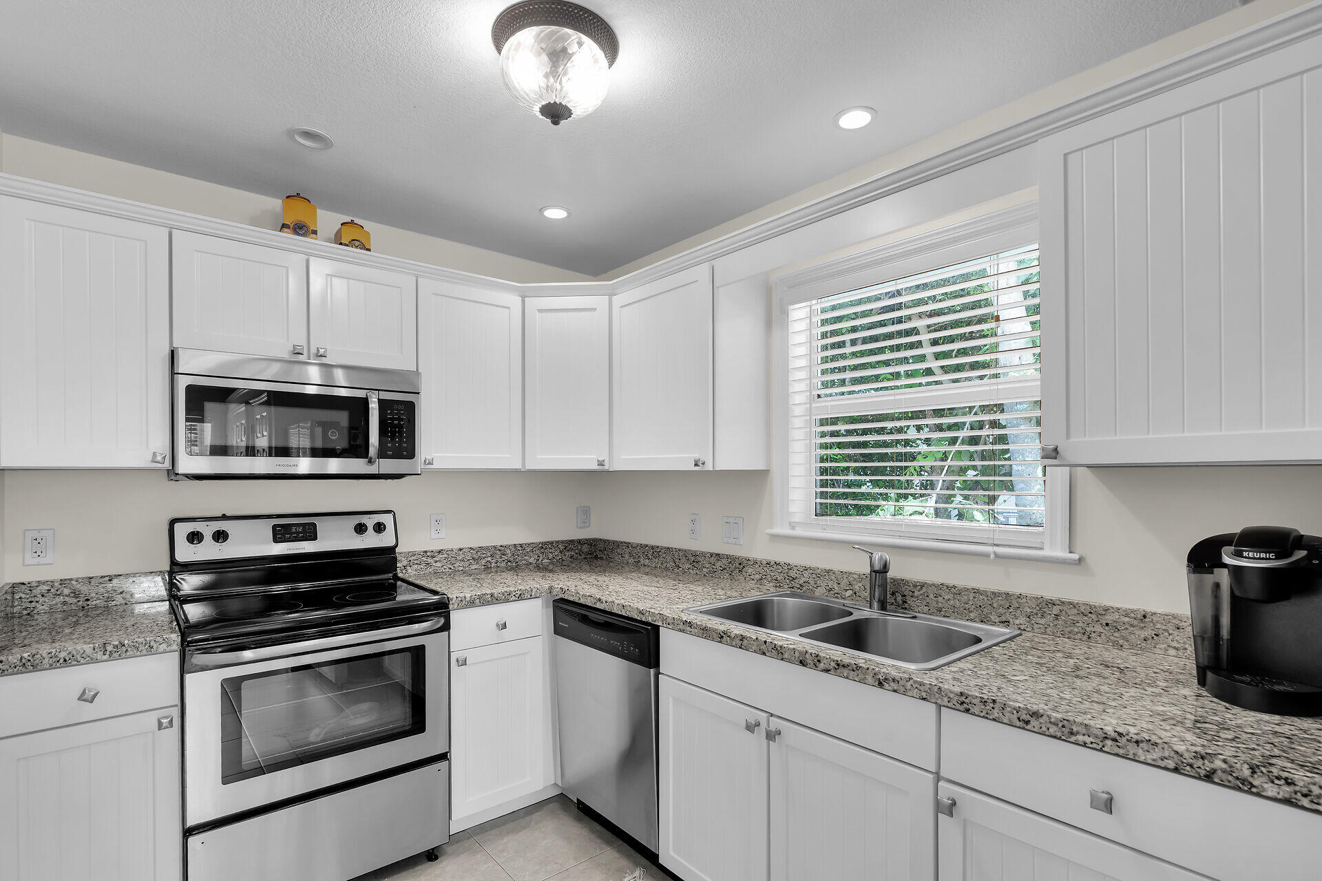 894 La Paloma Road Key Largo, FL 33037 - Photo 13 of 37 a kitchen with stainless steel appliances granite countertop a sink stove and cabinets