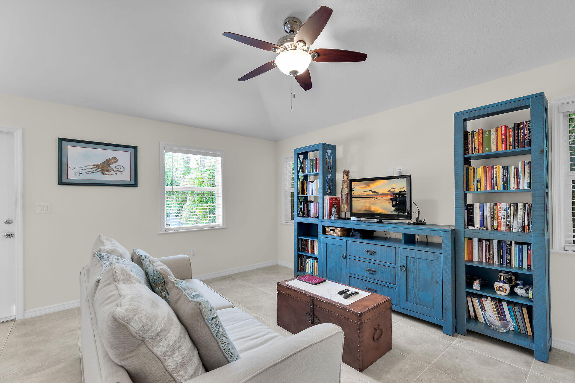 894 La Paloma Road Key Largo, FL 33037 - Photo 6 of 37 a living room with furniture a bookshelf and a flat screen tv