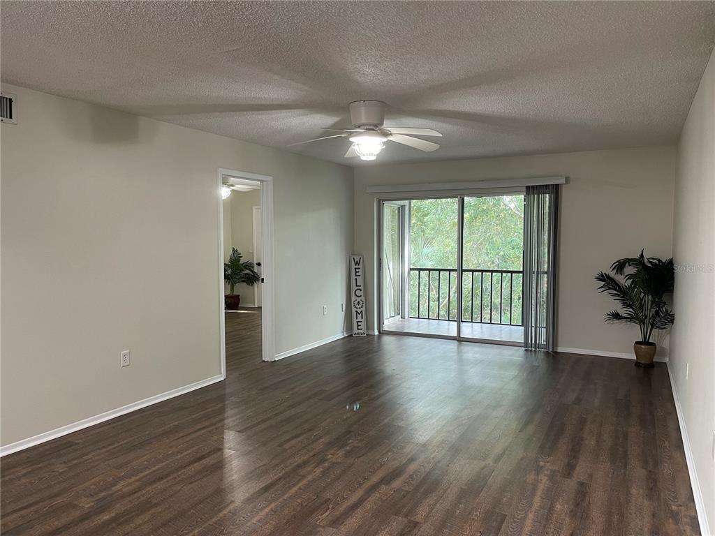 112 Palmetto Court, Unit 112 Oldsmar, FL 34677 - Photo 11 of 46 a view of an empty room with wooden floor and a window