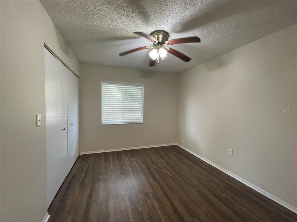 112 Palmetto Court, Unit 112 Oldsmar, FL 34677 - Photo 18 of 46 an empty room with wooden floor fan and windows