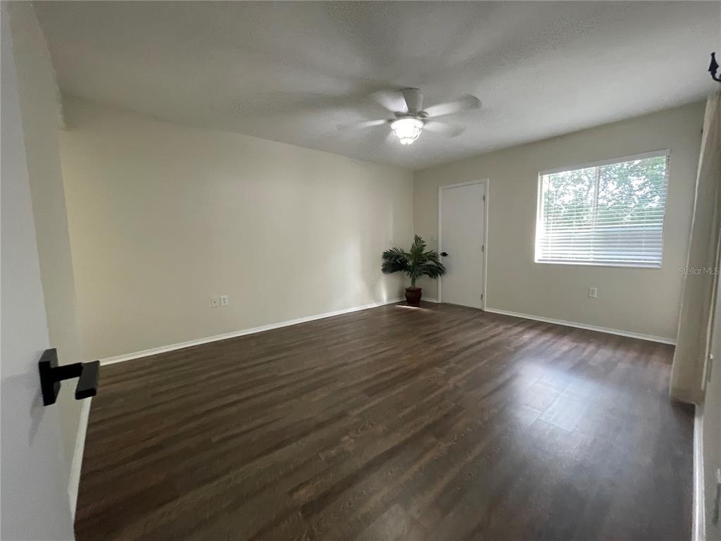 112 Palmetto Court, Unit 112 Oldsmar, FL 34677 - Photo 19 of 46 an empty room with wooden floor chandelier fan and windows