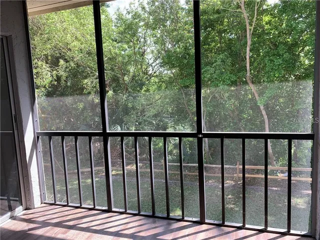 a backyard of a house with lots of plants and large trees
