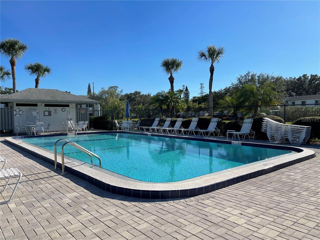 112 Palmetto Court, Unit 112 Oldsmar, FL 34677 - Photo 40 of 46 a view of a swimming pool with a table and chairs