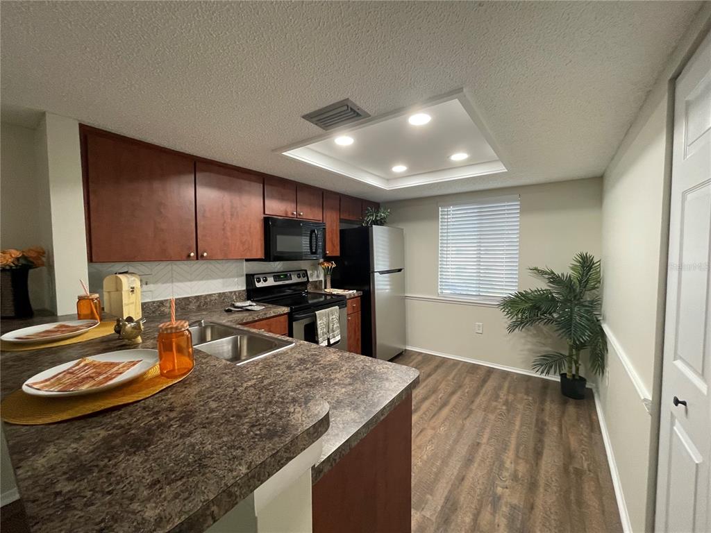 112 Palmetto Court, Unit 112 Oldsmar, FL 34677 - Photo 5 of 46 a kitchen with stainless steel appliances granite countertop a sink refrigerator and microwave