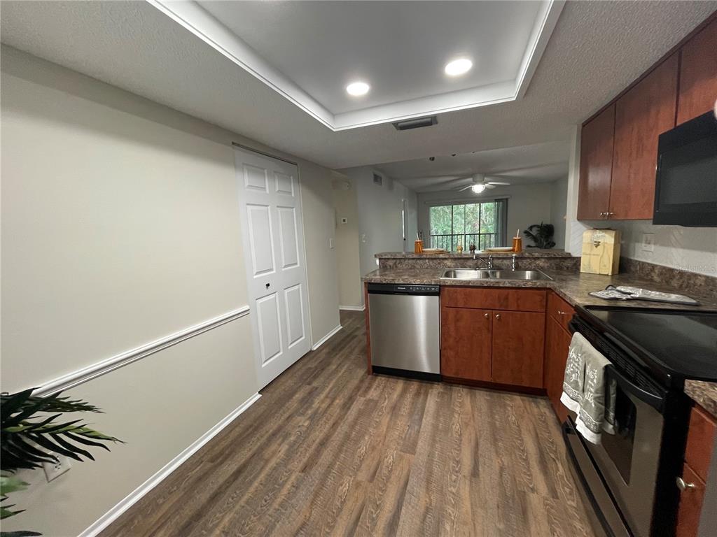 112 Palmetto Court, Unit 112 Oldsmar, FL 34677 - Photo 6 of 46 a kitchen with stainless steel appliances granite countertop a stove a sink dishwasher and a refrigerator with wooden floor
