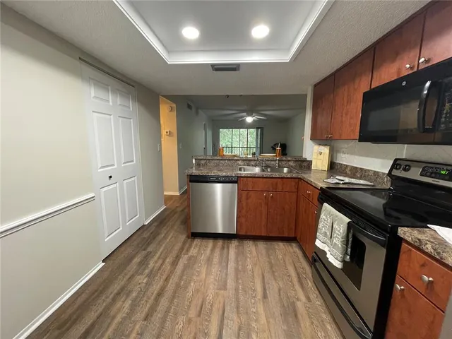 a kitchen with stainless steel appliances granite countertop a stove a sink and a microwave
