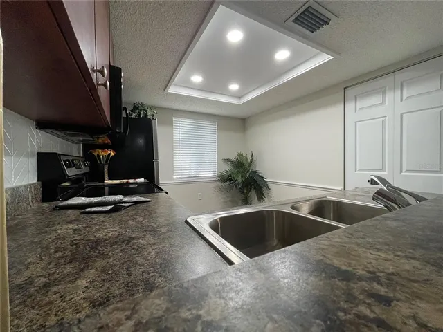 a kitchen with stainless steel appliances granite countertop a sink stove and refrigerator