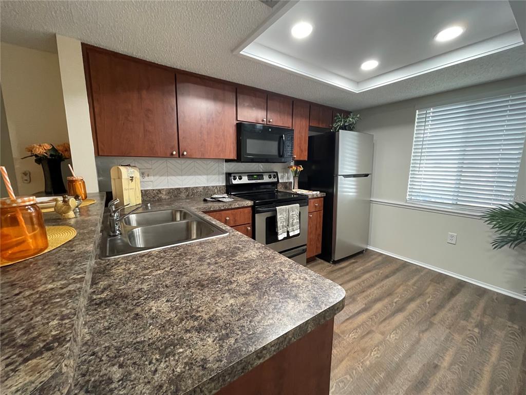 112 Palmetto Court, Unit 112 Oldsmar, FL 34677 - Photo 9 of 46 a kitchen with stainless steel appliances granite countertop a sink stove and refrigerator