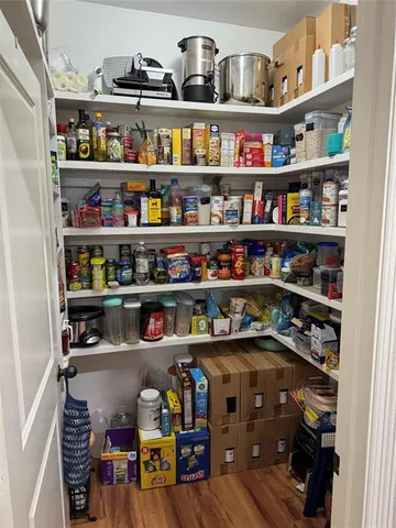 a bedroom with a bed ceiling fan and a wooden floor