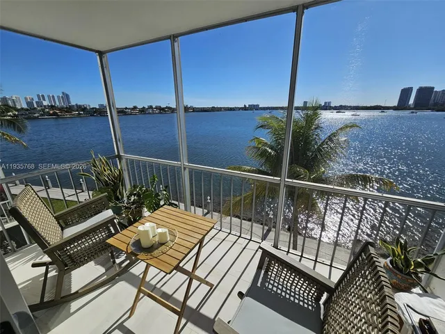 a balcony with wooden floor table and chairs