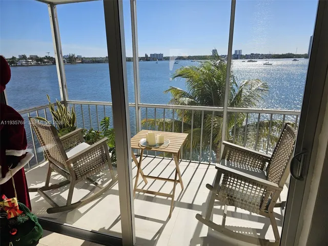 a view of a balcony with wooden floor next to a yard