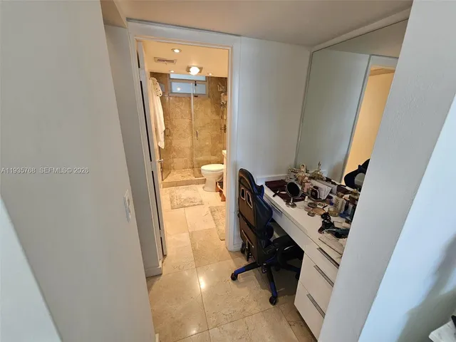 a bathroom with a sink and mirror with toilet